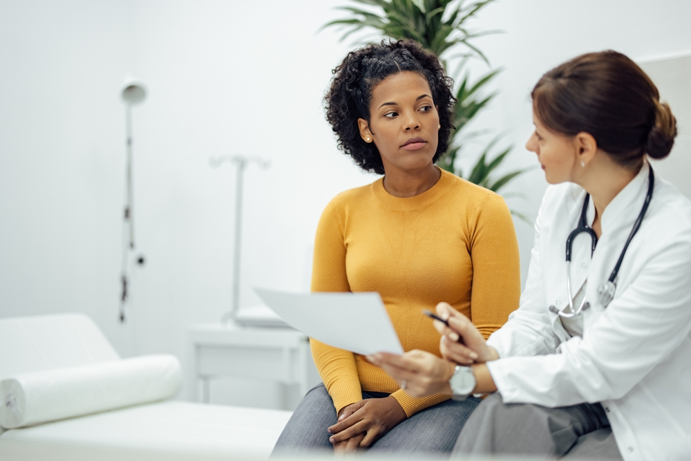 doctor holding paper while talking to patient